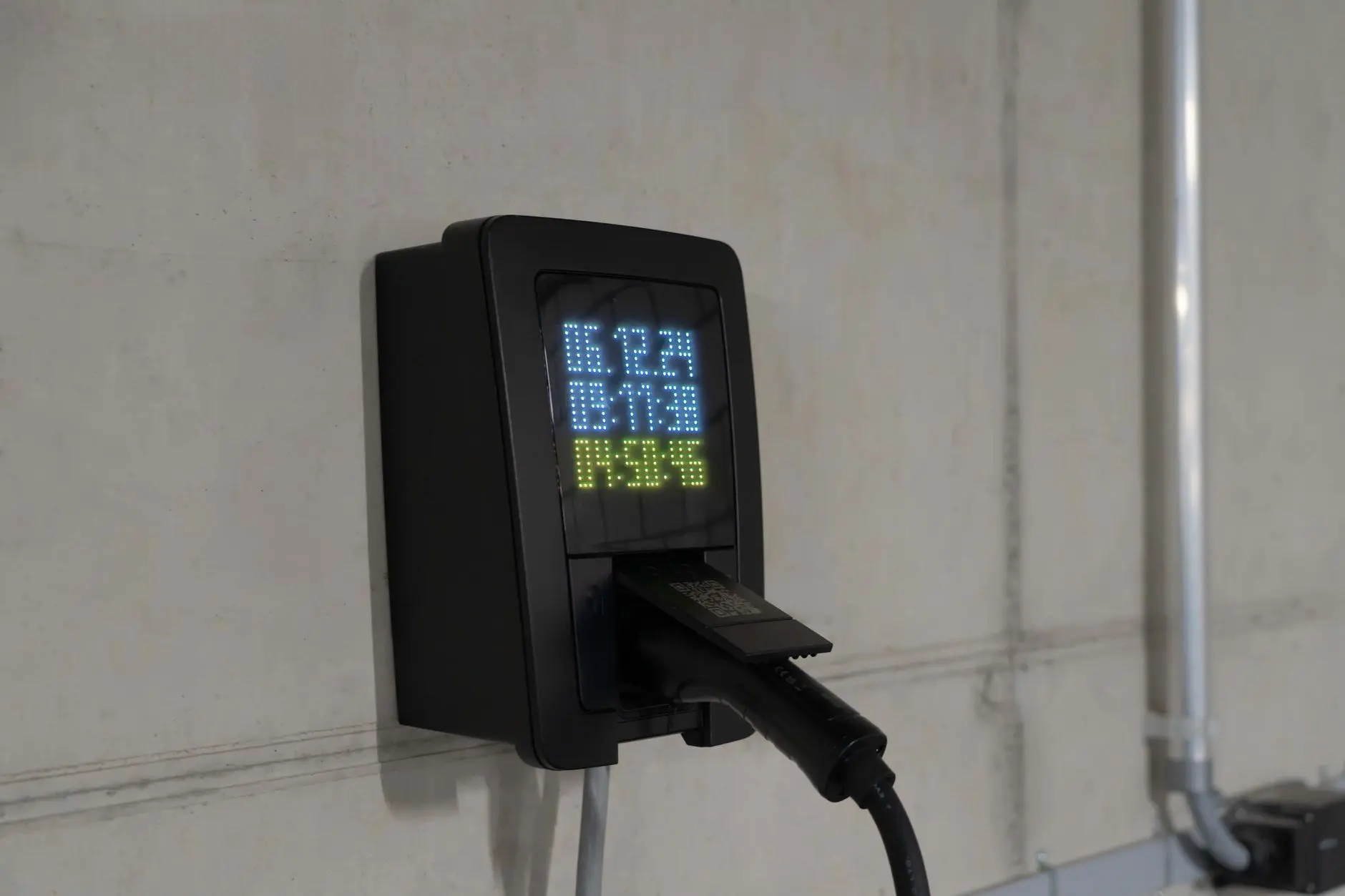Wallbox mit Ladeanzeige an einer Betonwand